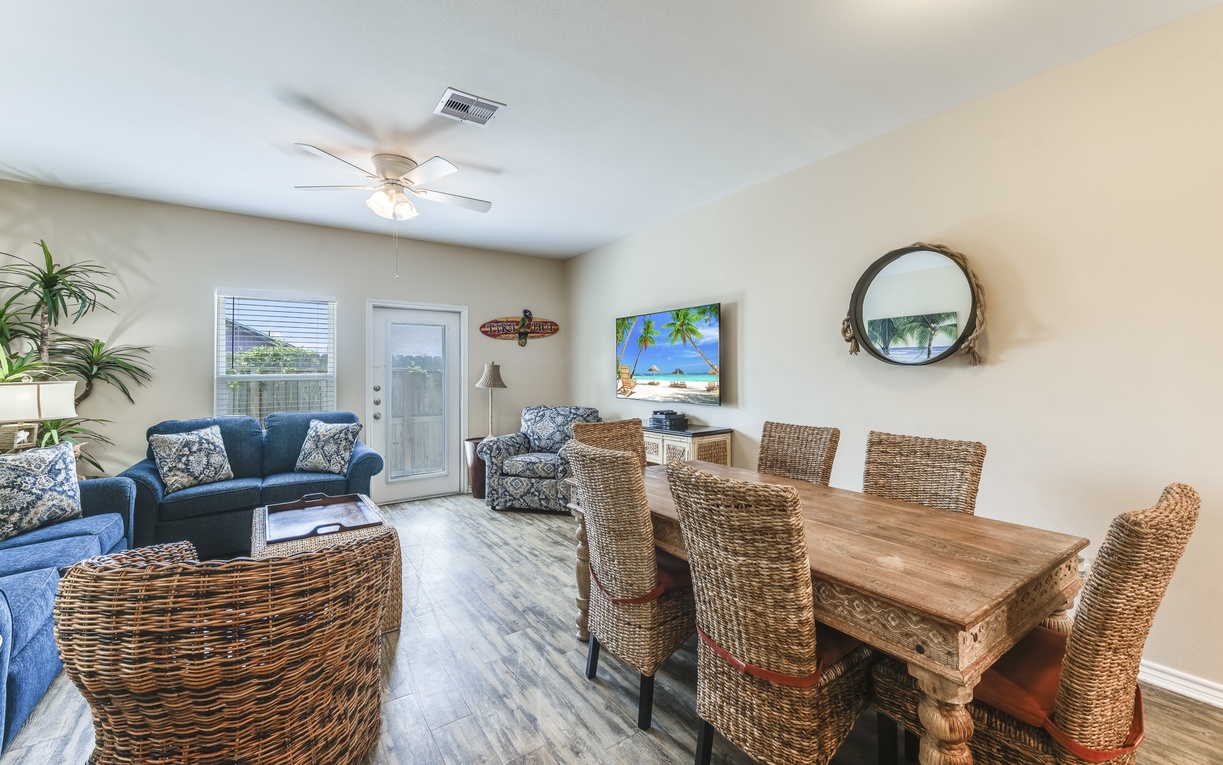 Relax in your spacious open-plan living area featuring coastal décor, comfortable seating, and tropical touches that create the perfect beach getaway atmosphere.