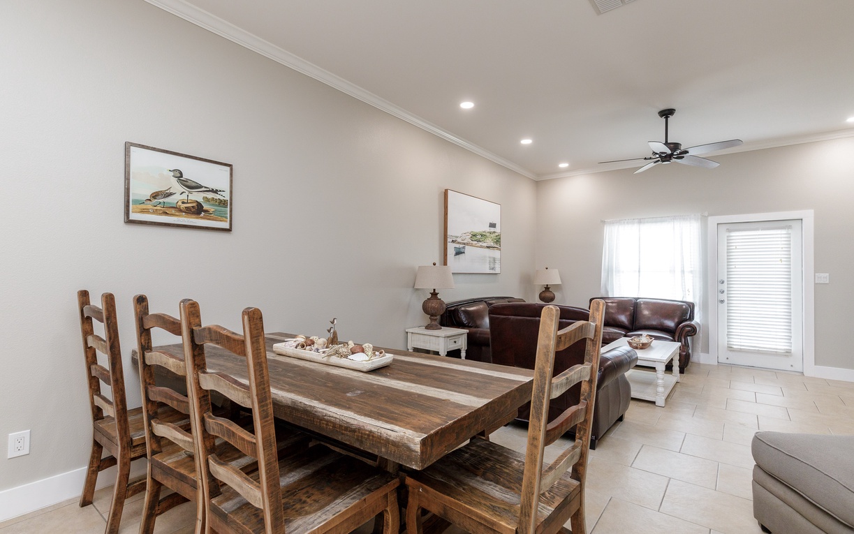 Gather around your spacious dining table for memorable meals in this bright, open-concept space with cozy leather seating nearby.