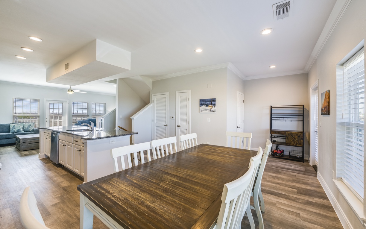 Gather around your spacious dining table where warm wood tones meet crisp white chairs, creating the perfect spot for memorable meals together.
