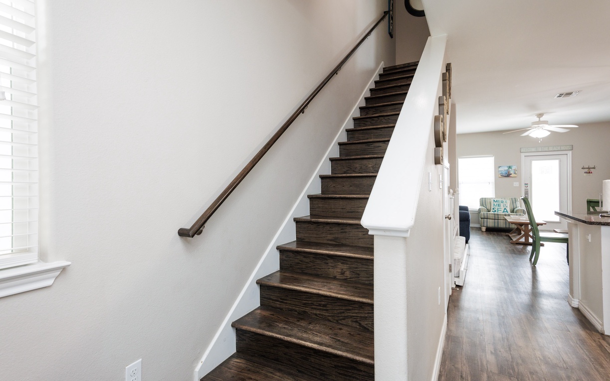 Ascend these beautiful dark wood stairs to your private upper level, where comfort awaits in this thoughtfully designed space.