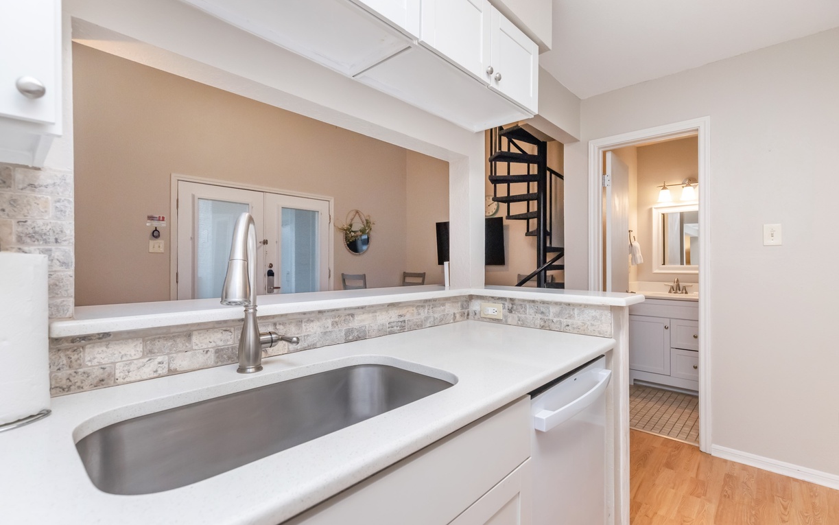 Your bright, modern kitchen features white quartz counters and stainless appliances, perfect for preparing meals during your stay.