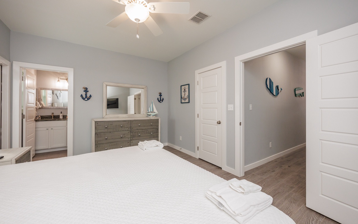 Your spacious primary bedroom features coastal charm with nautical touches, modern furnishings, ensuite bathroom, and king size bed.