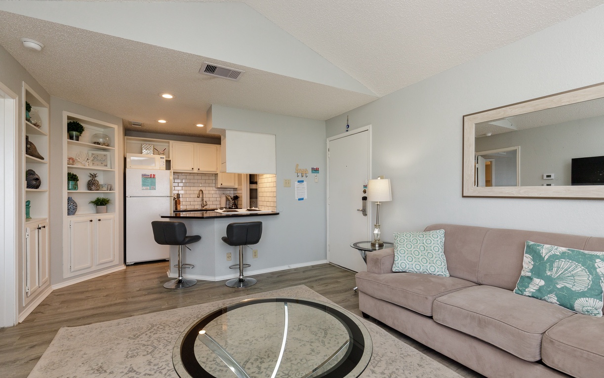 Settle into your open-concept living space where comfortable seating flows into a sleek kitchen perfect for morning coffee or evening meals together.