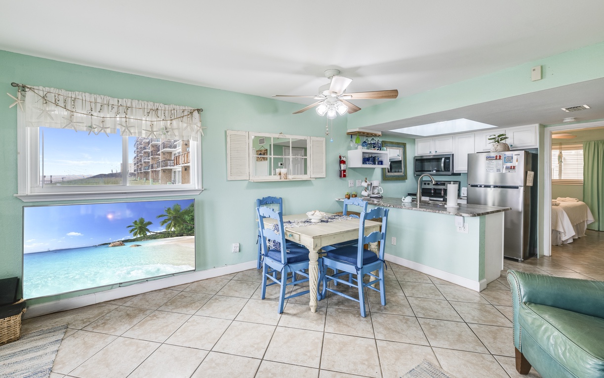 Your open-concept kitchen and dining area features tropical mint walls, beach-themed artwork, and everything needed for memorable meals together.