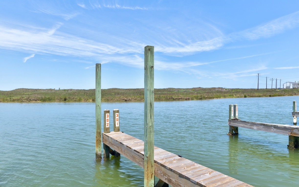Private boat docks stretch into tranquil waterfront waters, offering convenient access for fishing, kayaking, or peaceful mornings watching the sunrise over coastal marshlands.