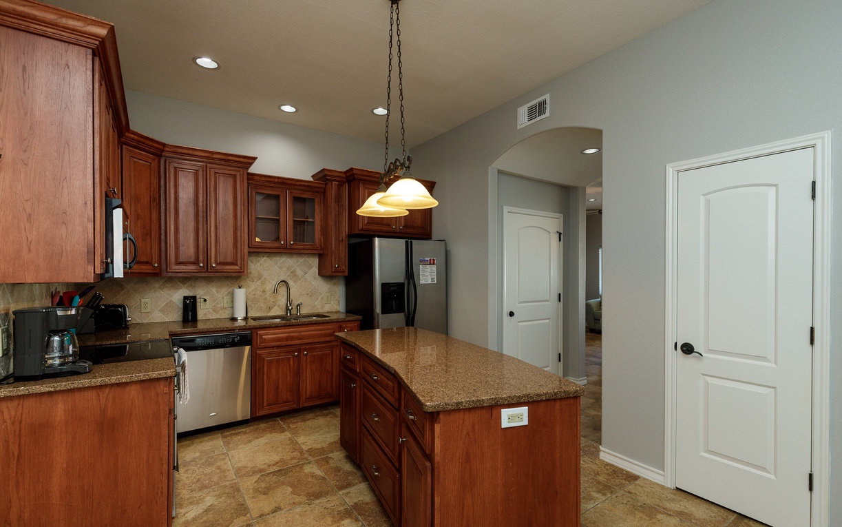 Cook your favorite meals in this spacious kitchen with rich cherry cabinets, granite counters, and stainless steel appliances.