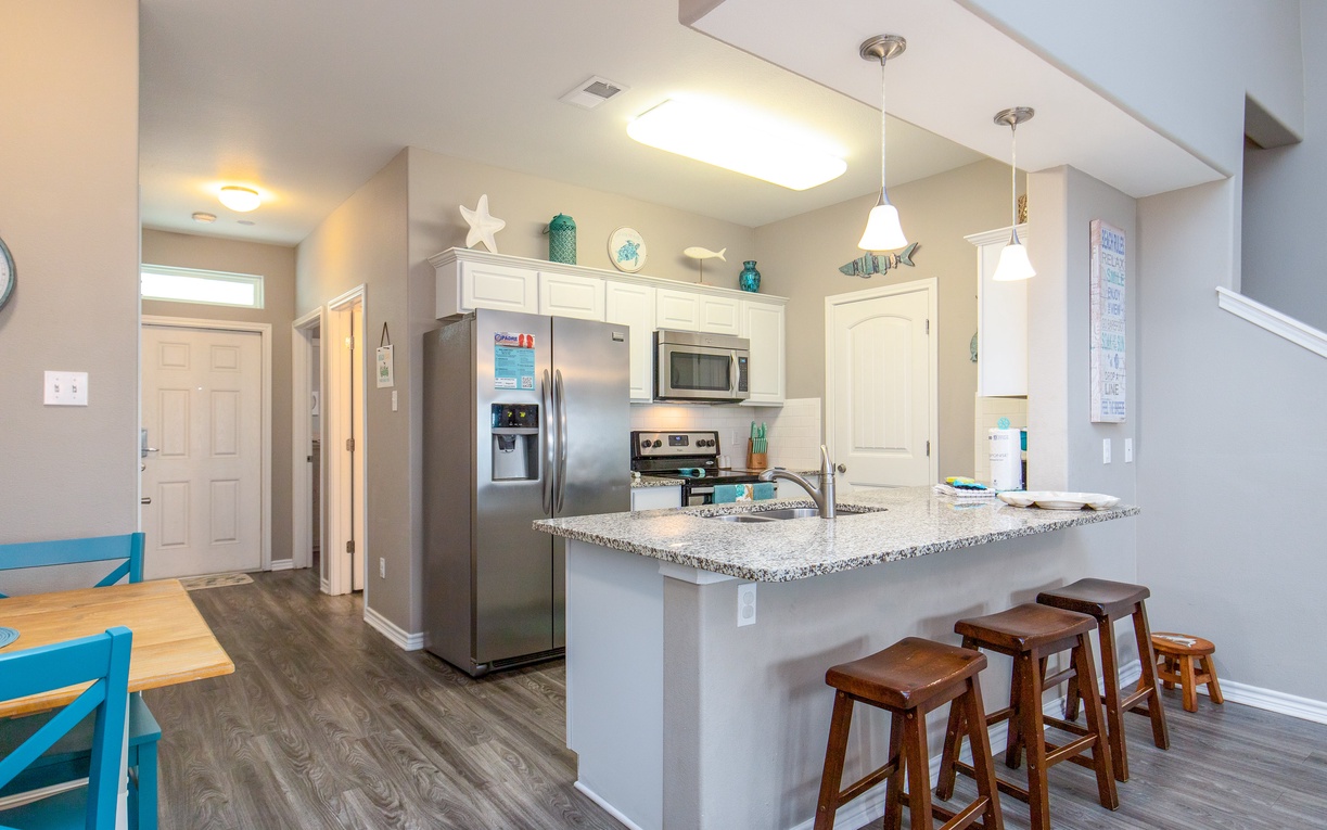 Your open kitchen invites relaxed mornings with granite counters, stainless appliances, and a breakfast bar perfect for coffee and conversation.