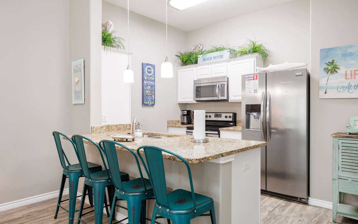 Your fully equipped kitchen features granite countertops, stainless steel appliances, and cheerful coastal décor that makes cooking feel like a beach vacation.