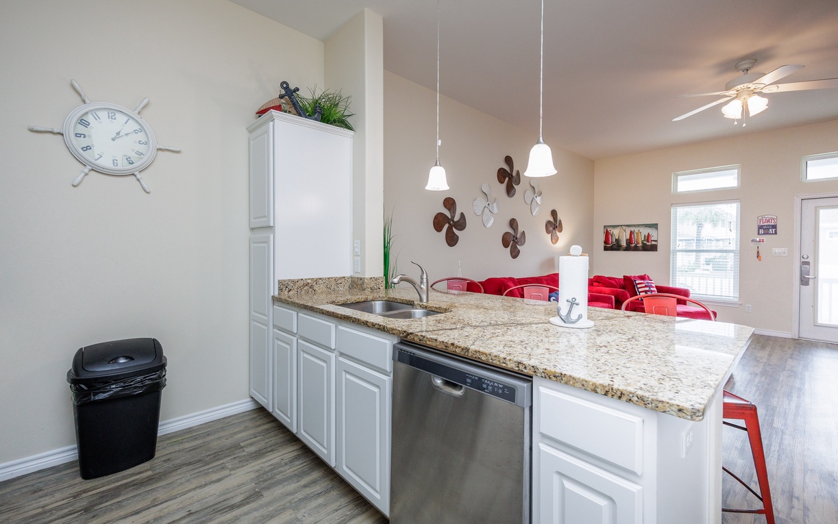 Your fully equipped kitchen features granite countertops, modern appliances, and pendant lighting, perfect for preparing meals together.