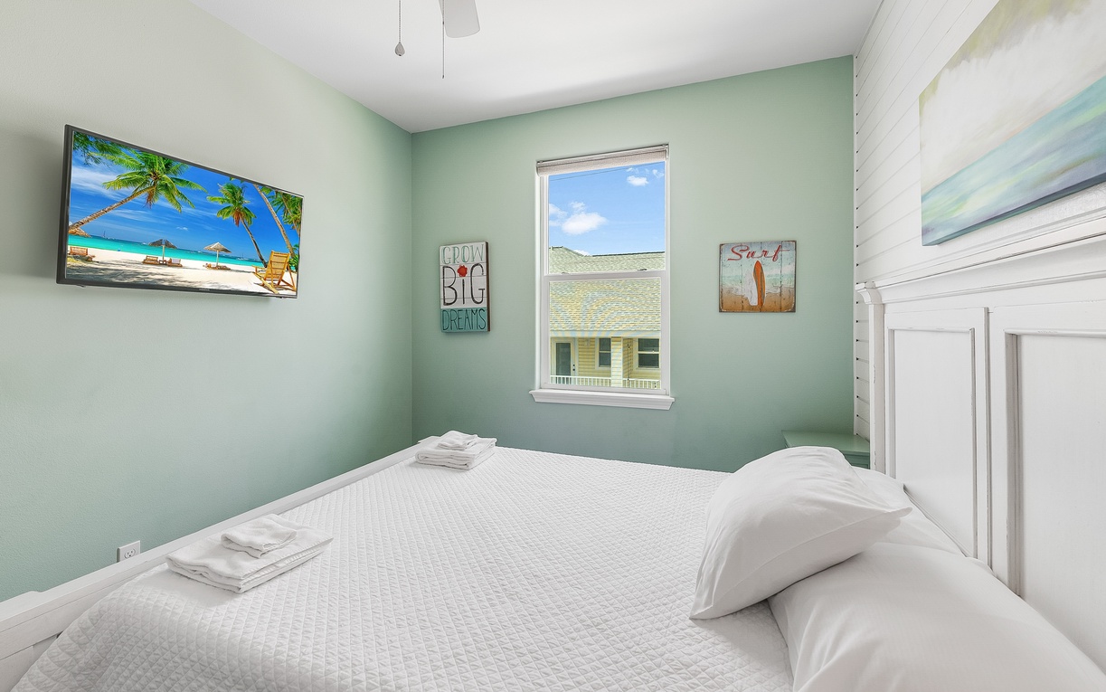 Drift off in this peaceful bedroom with tropical artwork and soft mint walls creating your perfect coastal retreat.