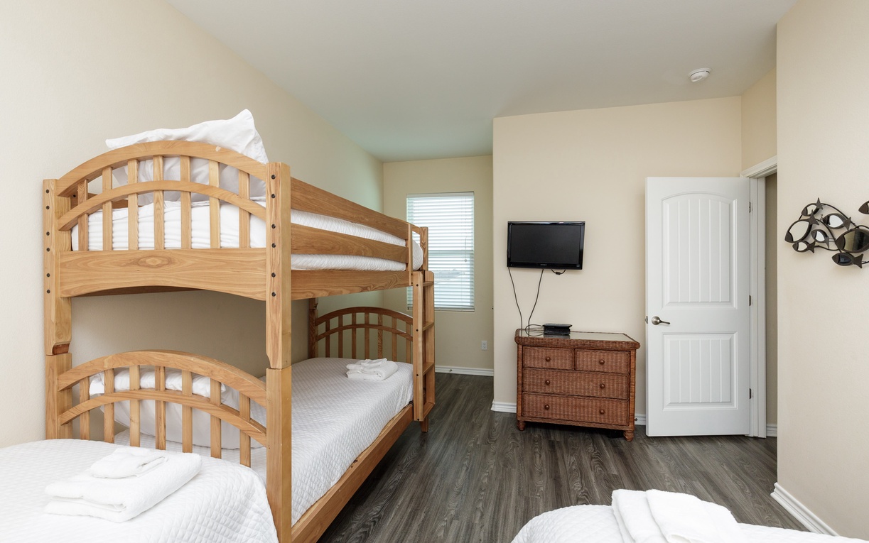 Your family bedroom features cozy bunk beds and entertainment for memorable vacation nights together.