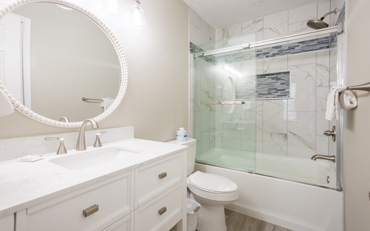 Unwind in your elegant marble bathroom featuring a luxurious glass-enclosed tub and shower combo with stylish tile accents.