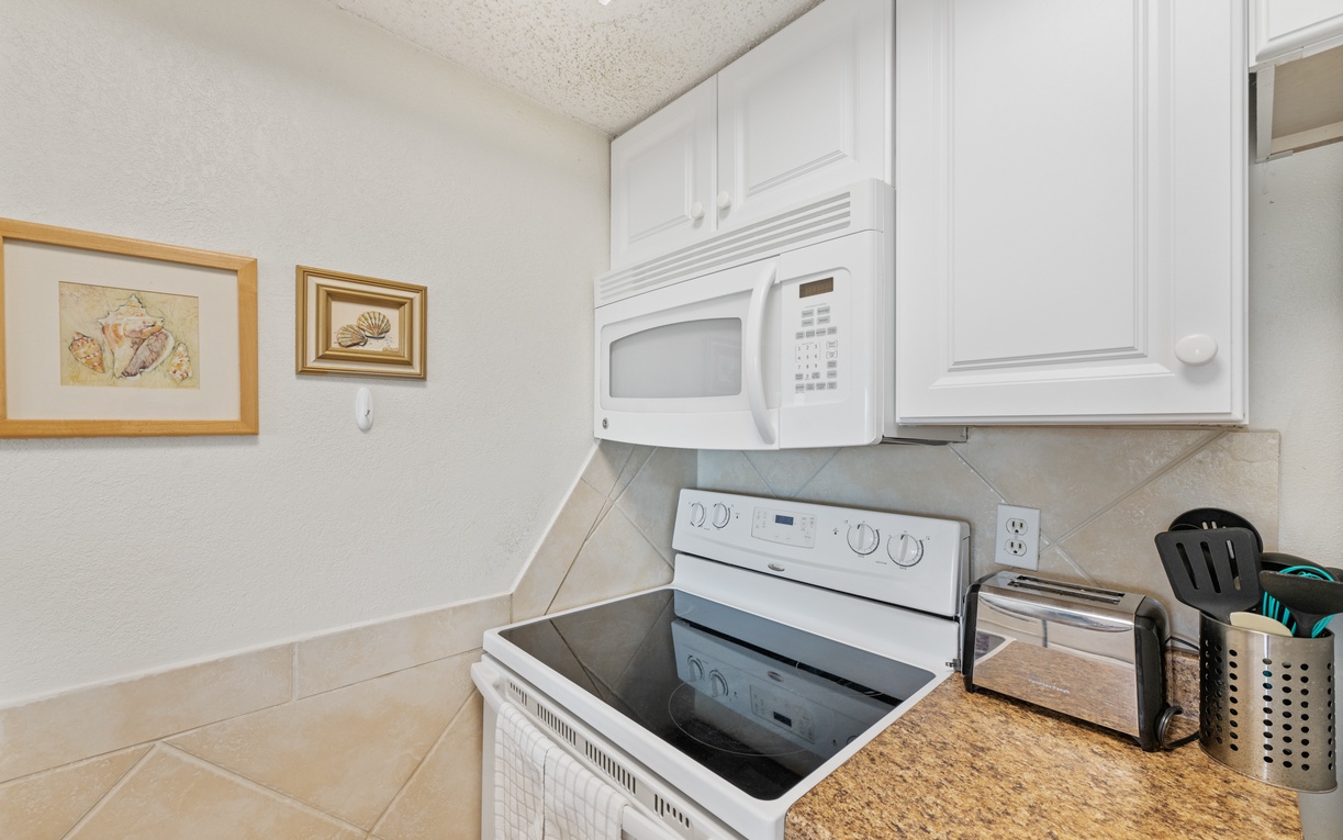 Your fully equipped kitchen awaits with modern appliances, granite countertops, and charming artwork to inspire your culinary adventures.