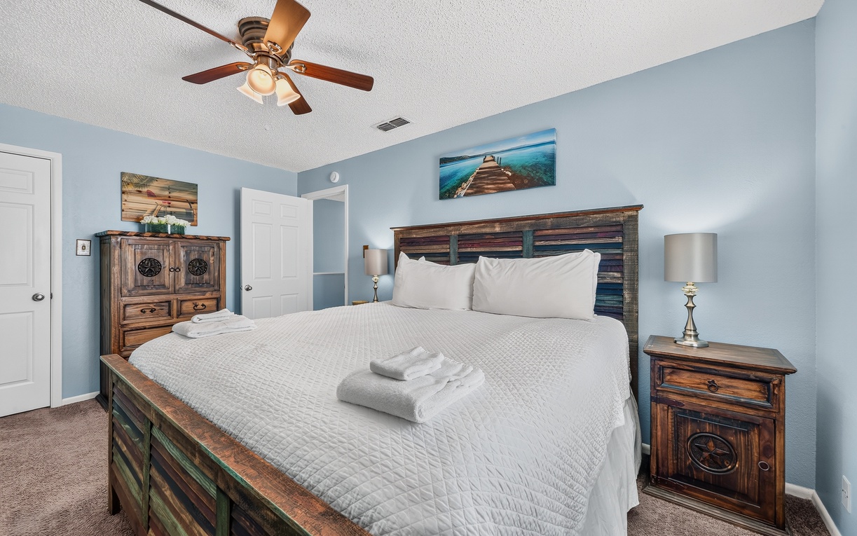 Sink into crisp white linens and drift off beneath the soothing coastal hues. Your bedside awaits with thoughtful touches and room to unwind.