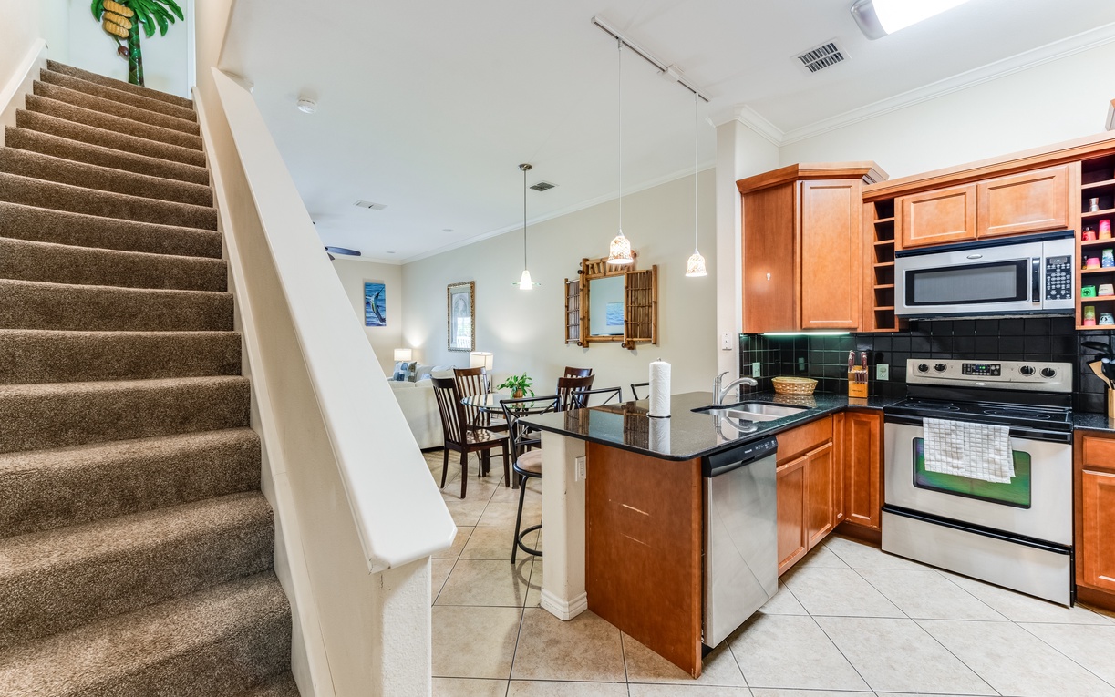 Your open-concept kitchen flows seamlessly into the dining area, where warm wood cabinets and granite counters invite you to cook memorable meals together.