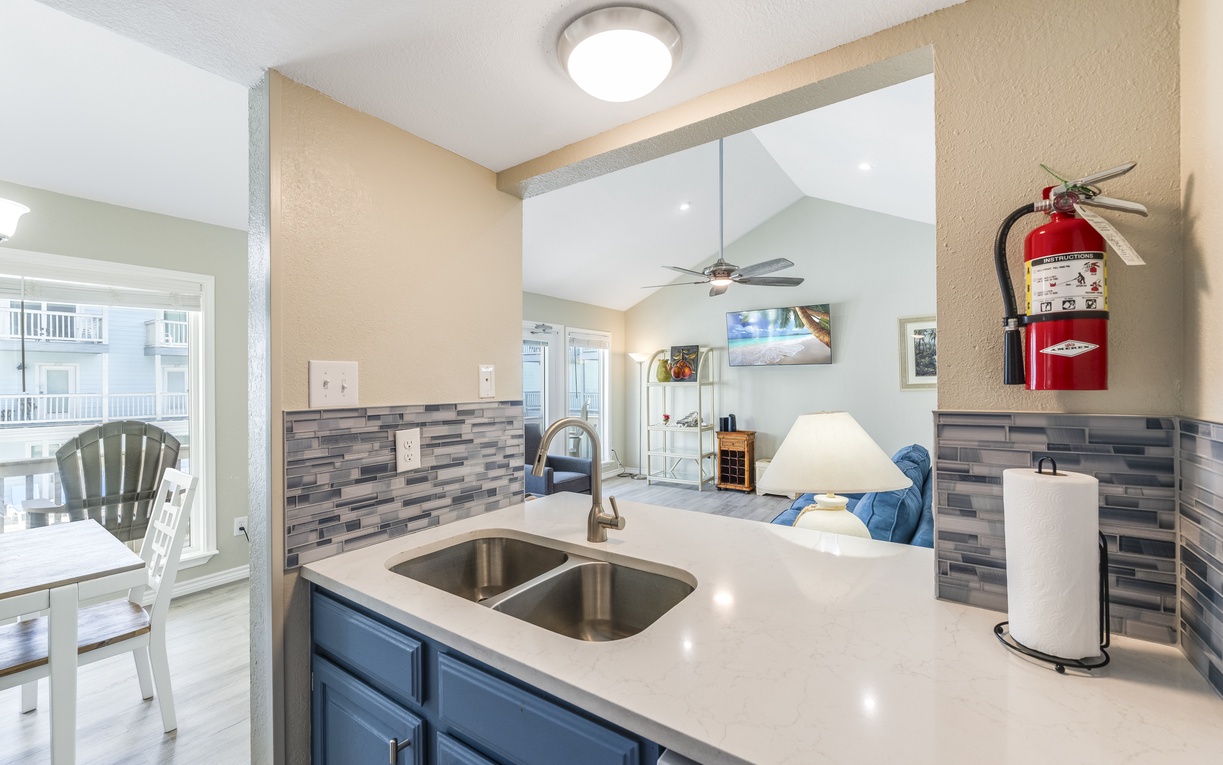 Your modern kitchen flows seamlessly into the living area, with sleek countertops and stylish backsplash creating the perfect space to cook and connect.