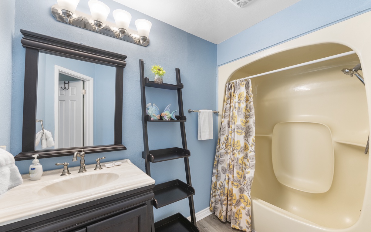 Refresh in your private bathroom with soothing blue walls, elegant vanity, and a spotless shower with thoughtful touches.