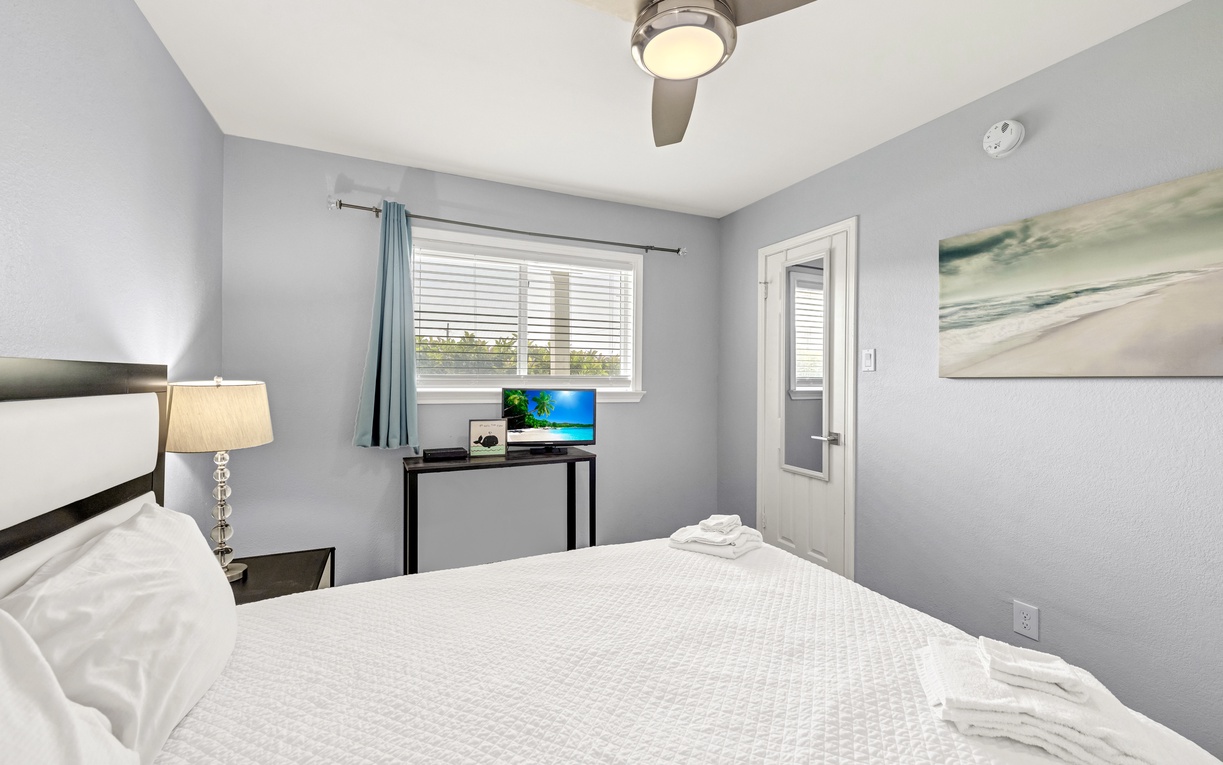 Unwind in your peaceful bedroom featuring crisp linens, a ceiling fan for comfort, and a queen size bed.