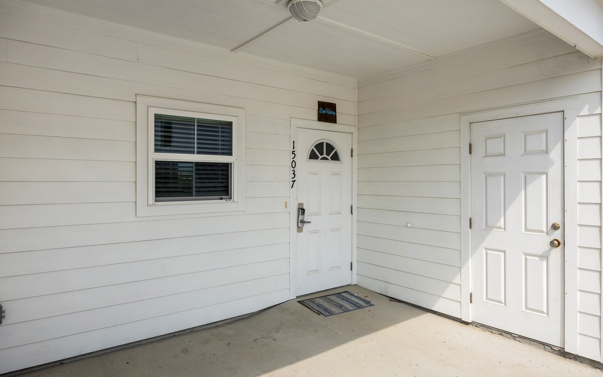 Clean white entrance with twin doors and covered porch provides a welcoming arrival to your comfortable retreat.