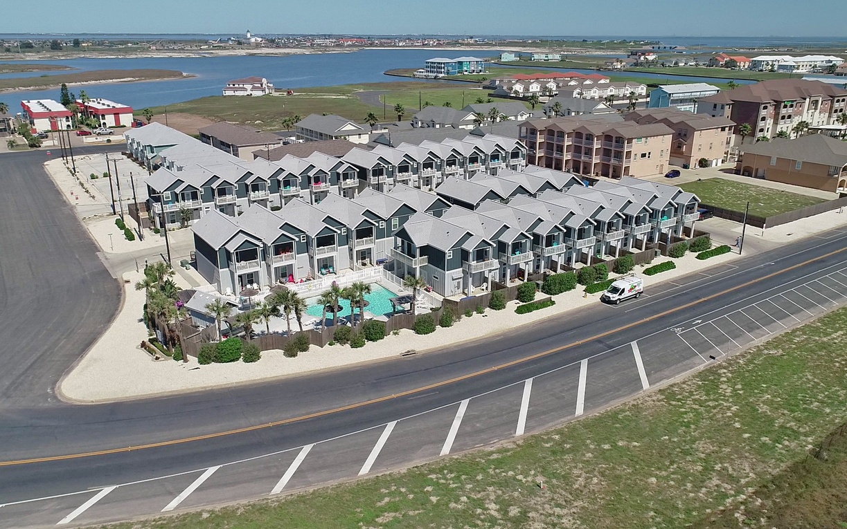 Modern beachfront townhomes with pool amenities sit moments from the water in this coastal community development.