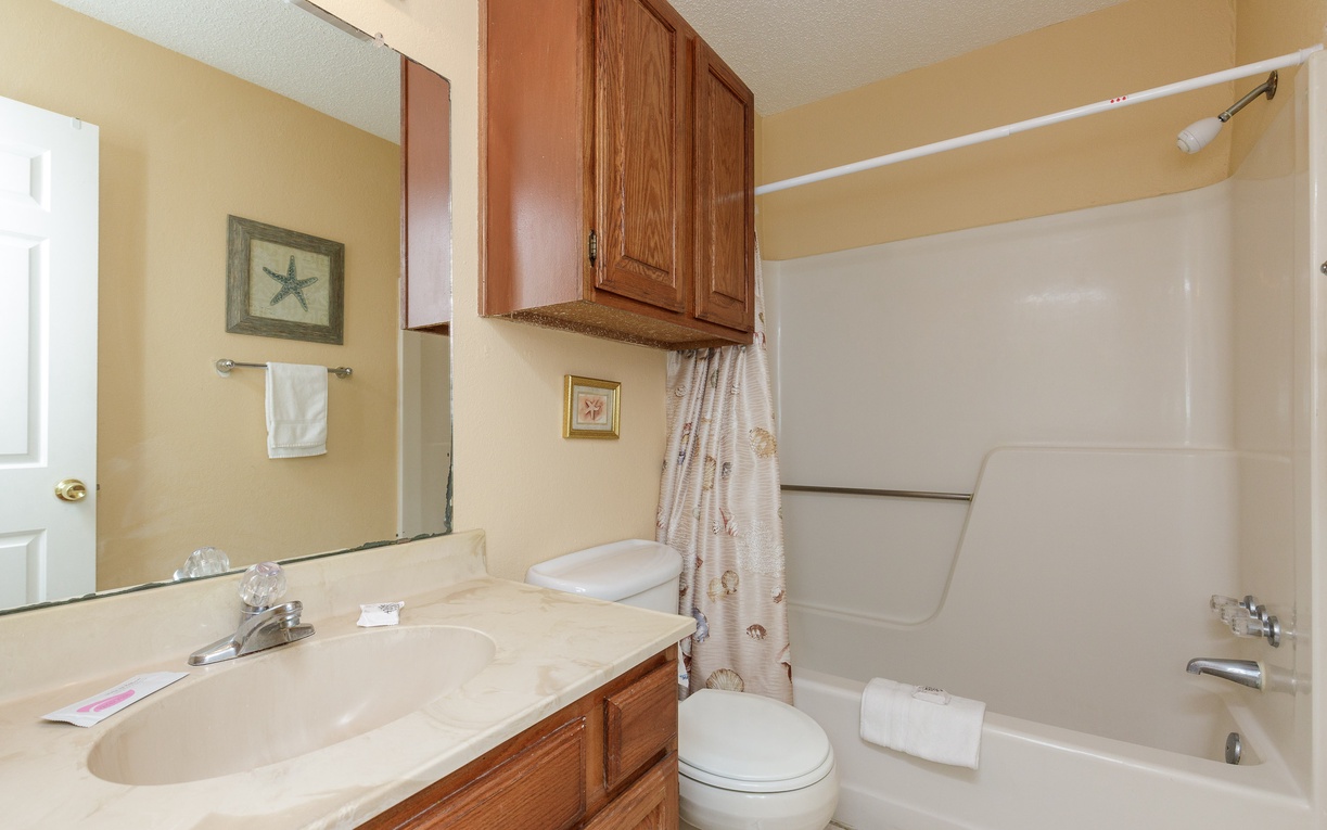 Relax in your private bathroom with full tub, shower, and warm coastal touches that make you feel right at home.