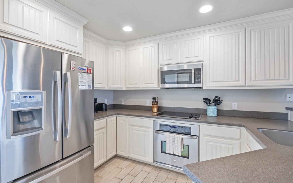 Your fully equipped kitchen awaits with gleaming stainless steel appliances, ample counter space, and everything you need to create memorable meals.