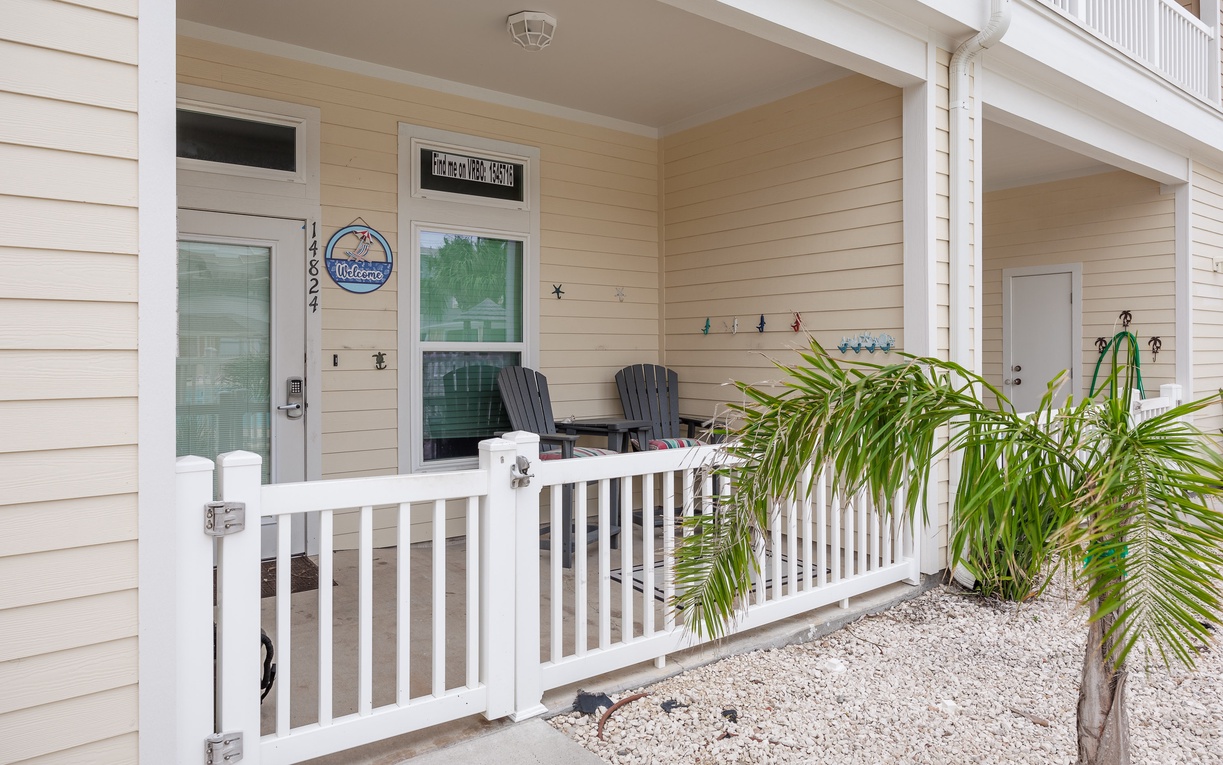 Your welcoming front porch with comfortable Adirondack chairs and tropical palms creates the perfect spot to unwind.