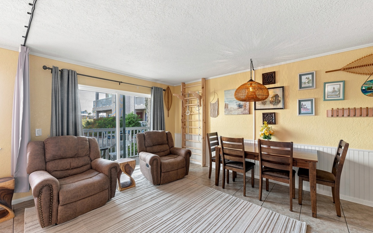 Settle into comfortable recliners after a day of adventure, gather around the dining table for meals, and enjoy your own balcony access with natural light flooding this inviting living space.