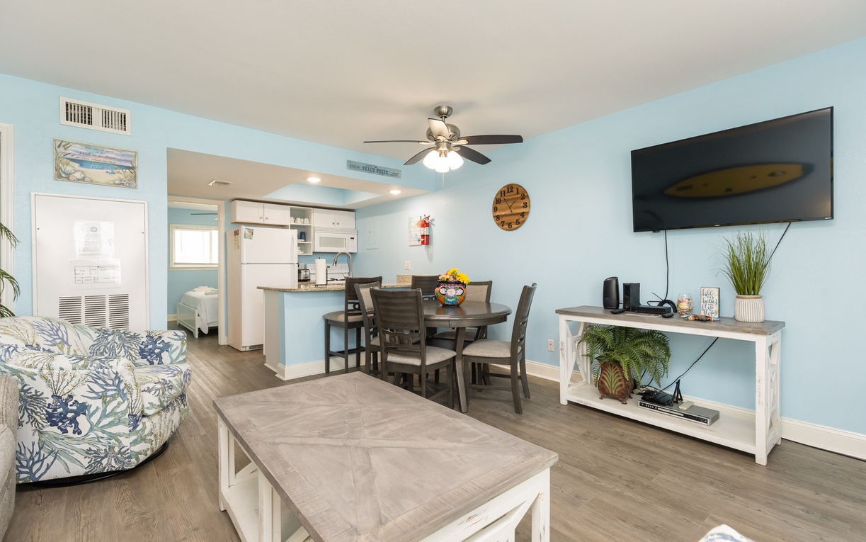 Your bright, coastal-themed living space flows seamlessly from living room to kitchen, perfect for relaxing with tropical-inspired furnishings and modern amenities.