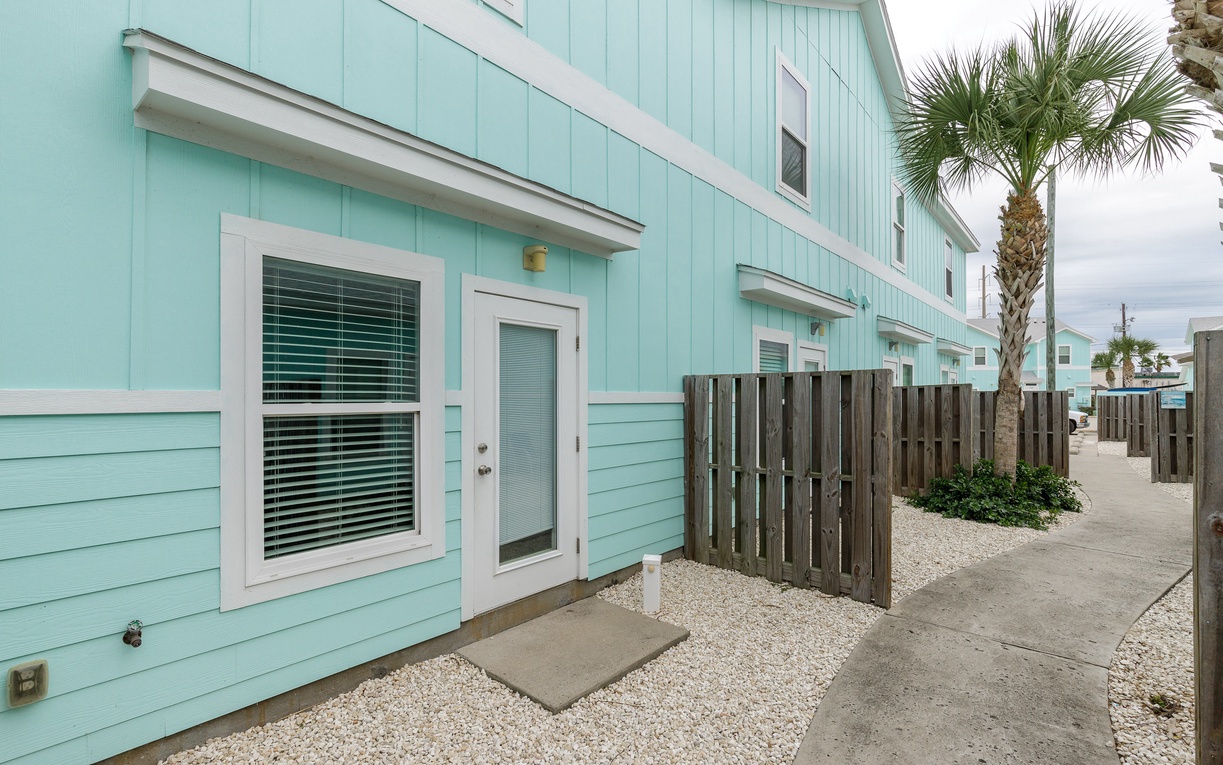 Charming turquoise cottage with tropical palms creating a perfect coastal retreat atmosphere.