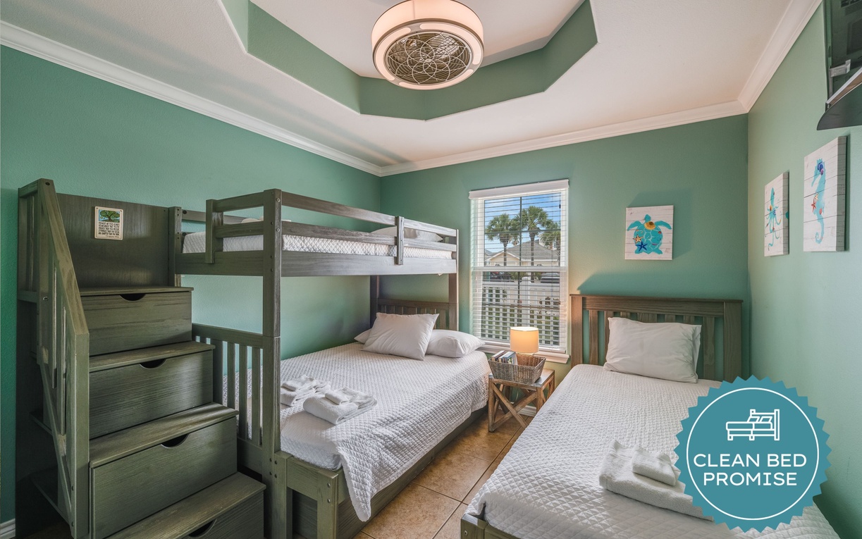Your seaside-inspired bedroom features a cozy bunk bed and twin bed, perfect for families or friends sharing ocean adventures together.