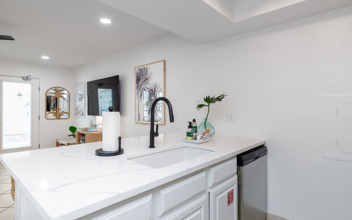 Your sleek kitchen island awaits with marble countertops and modern black fixtures, perfect for morning coffee prep.