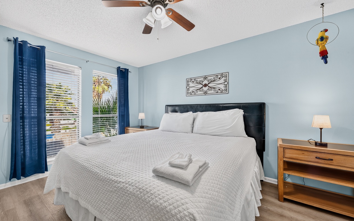 Step into your tranquil bedroom retreat, where soft blue walls and crisp white linens create a calming atmosphere. Natural light pours through the windows, and gentle breezes from the ceiling fan help you unwind after a day of adventure.