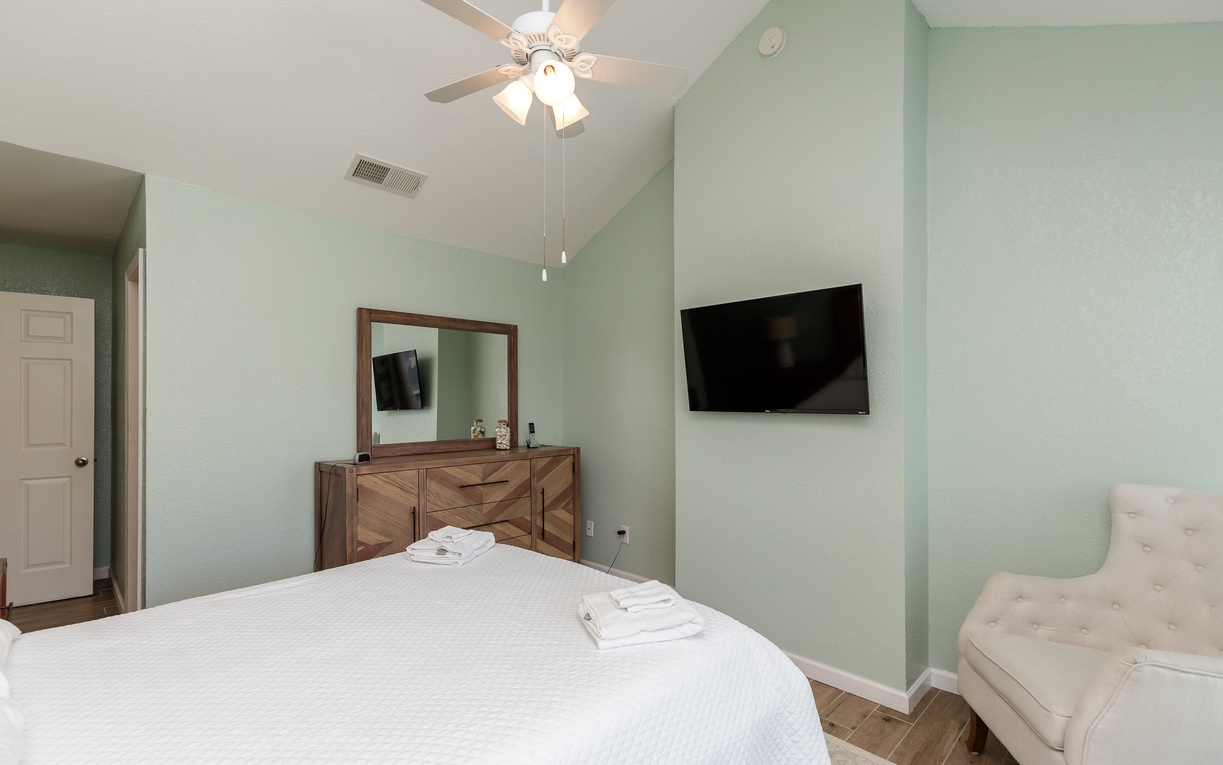Primary bedroom with queen size bed, private balcony, and private bathroom