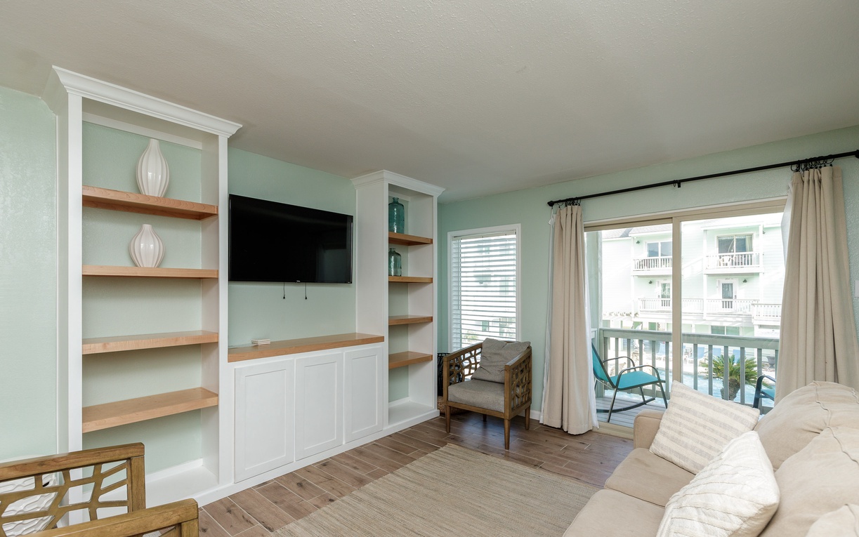 Relax in your bright living space with custom built-ins, flat-screen TV, and private balcony overlooking the neighborhood.