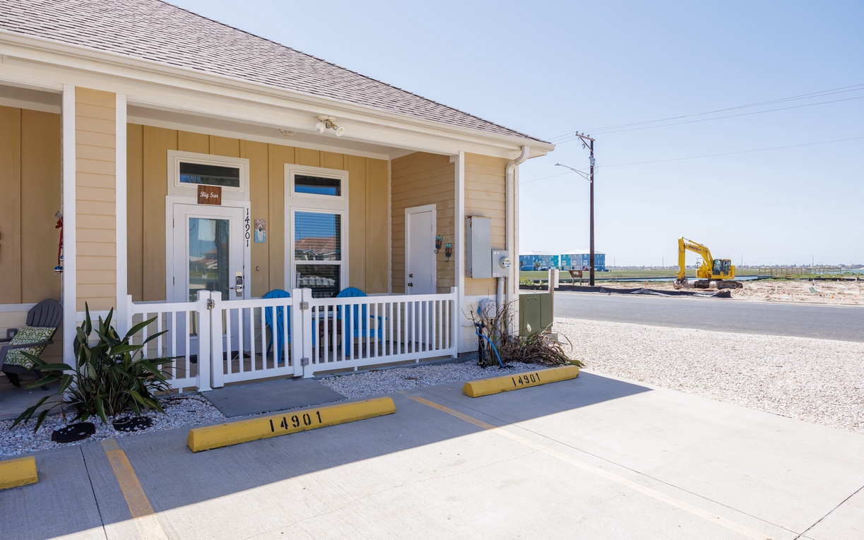 Charming coastal property entrance with welcoming front porch and easy parking access in a peaceful beachside community.