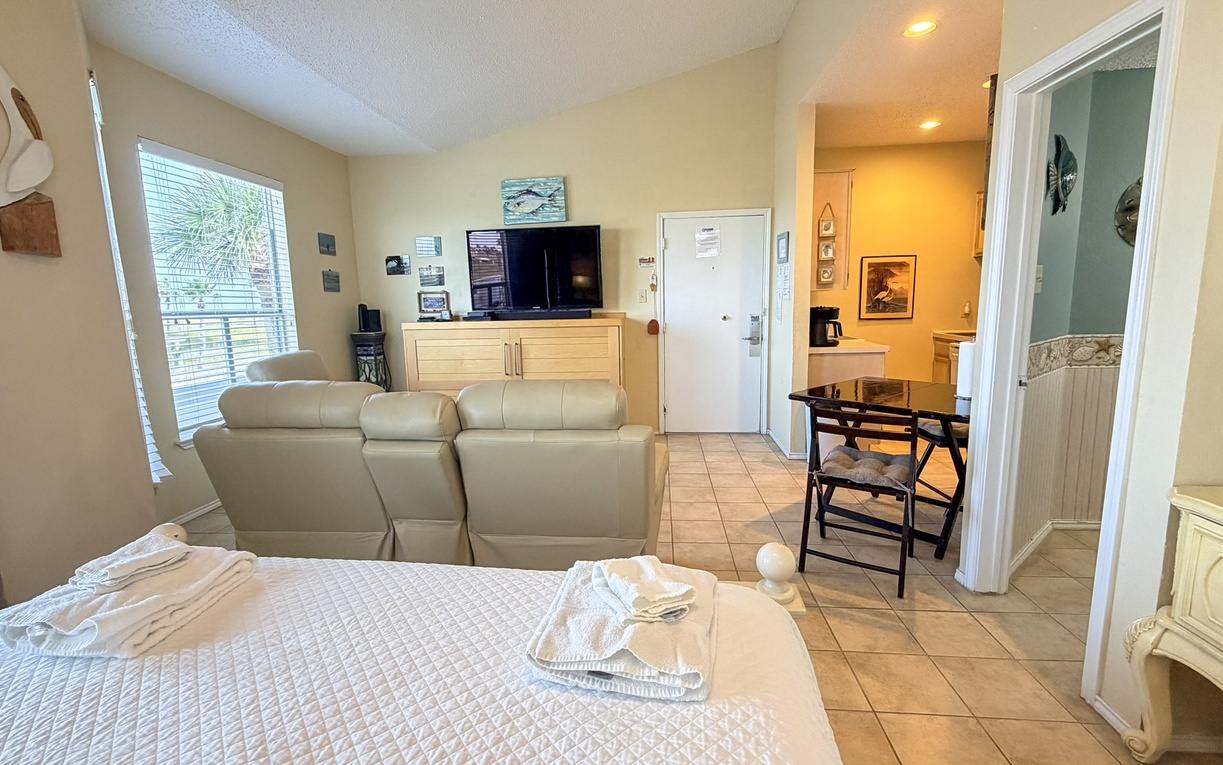 Your spacious studio welcomes you with comfortable seating, coastal charm, and an open layout connecting living and sleeping areas perfectly.