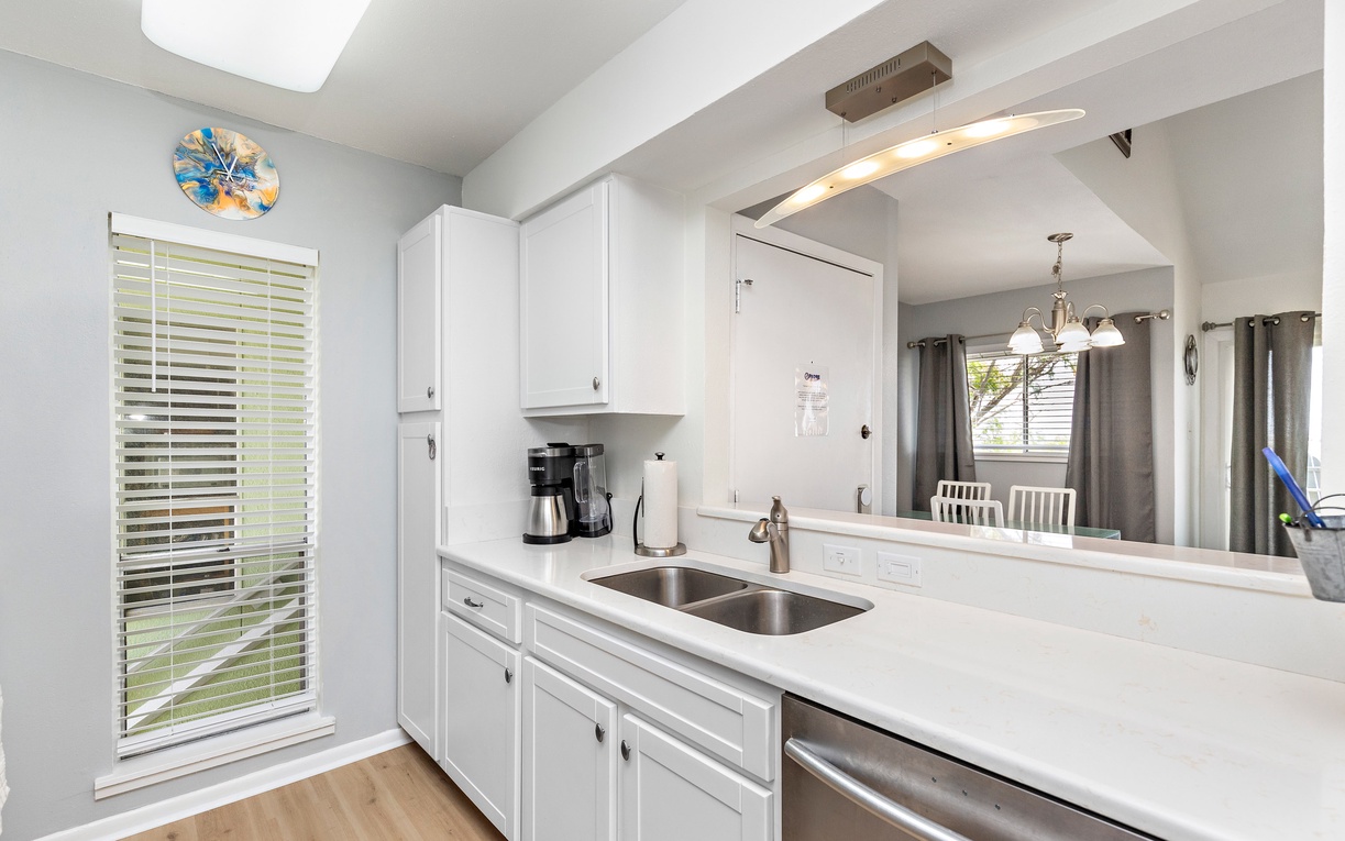 Cook your favorite meals in this bright, modern kitchen with pristine white cabinets, sleek countertops, and all the essentials you need.