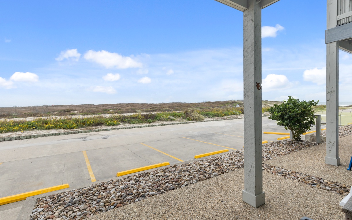 Convenient covered parking spaces with natural landscape views beyond the property grounds.