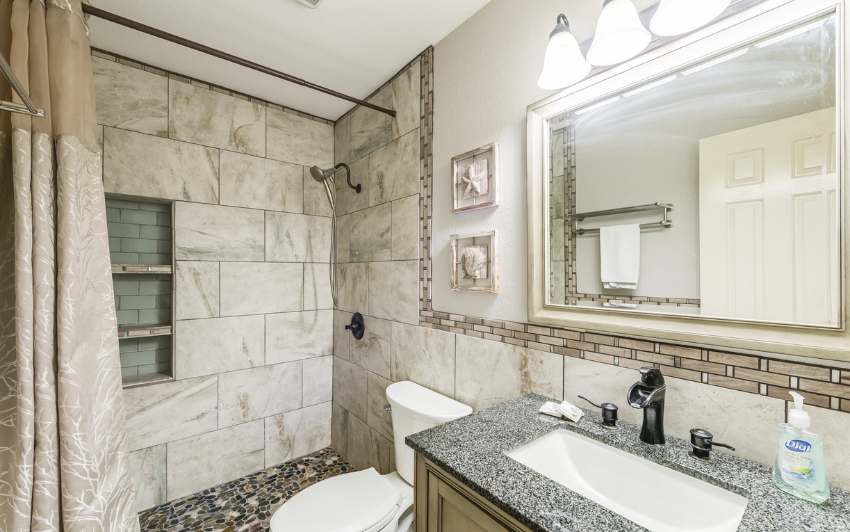 Step into your luxurious marble bathroom featuring a rainfall shower, granite countertops, and thoughtful touches for your comfort.