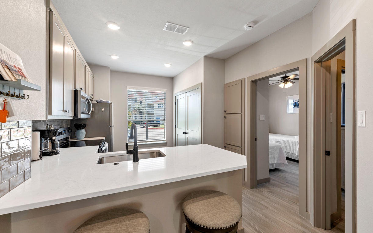 Your modern kitchen awaits with sleek countertops, subway tile backsplash, and bar seating perfect for morning coffee or casual meals together.