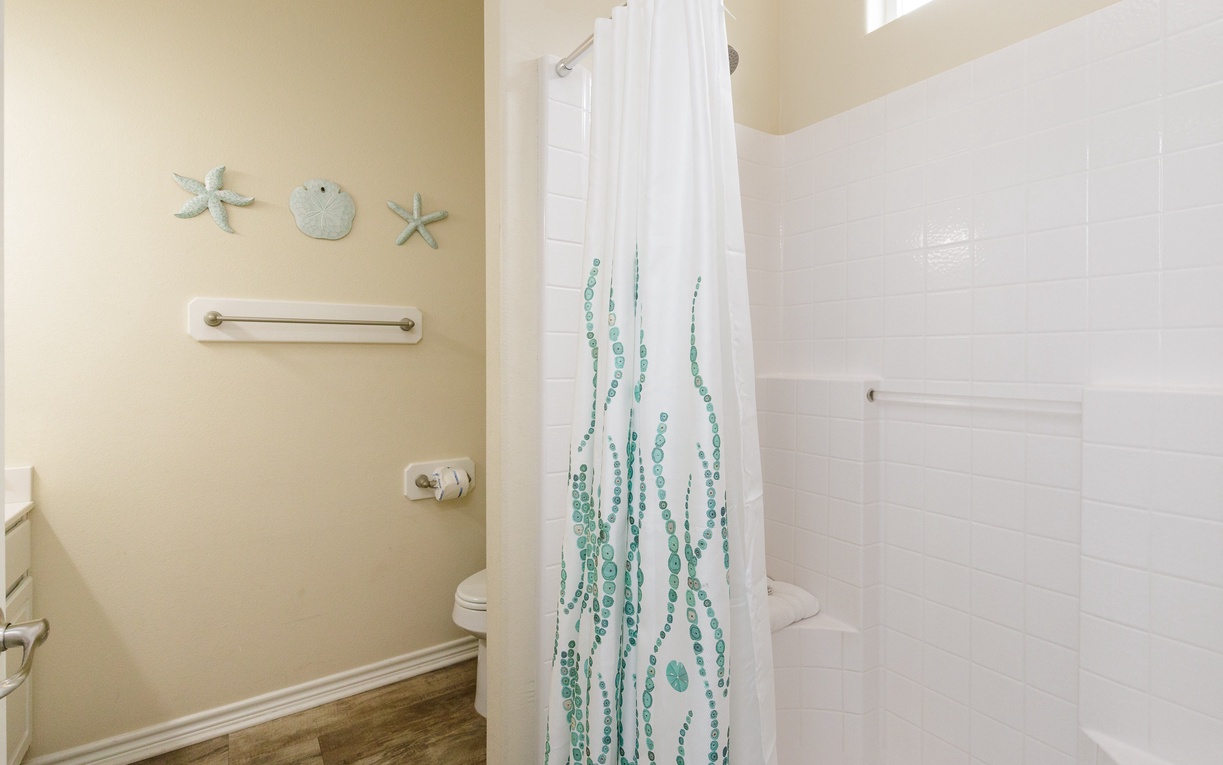 Your private bathroom features a spacious shower with coastal-themed décor and charming sea life touches that transport you to a peaceful seaside retreat.
