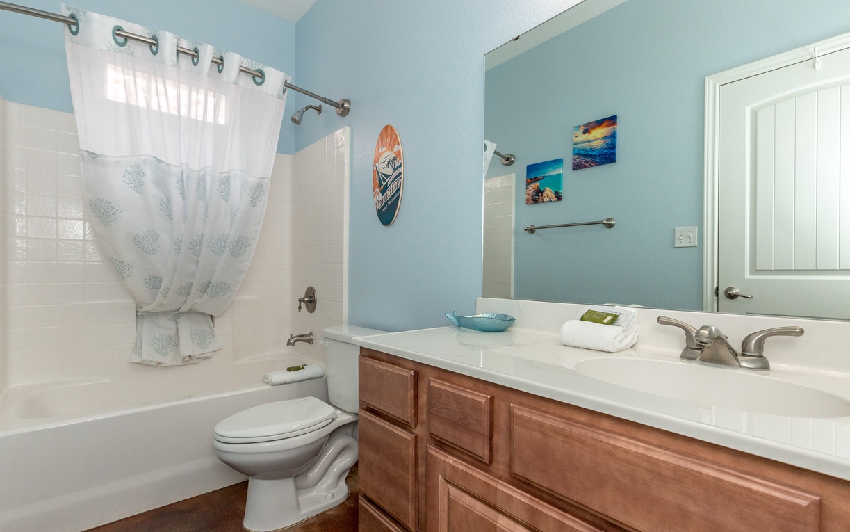 Step into your coastal-themed bathroom with soothing ocean blues and beach artwork that instantly transport you to seaside serenity.
