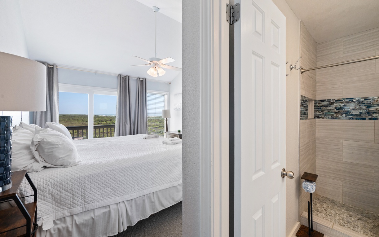 Slip into your private ensuite, where a beautifully tiled walk-in shower awaits. The coastal-inspired accent wall adds a calming touch to refresh you after a day of adventure.