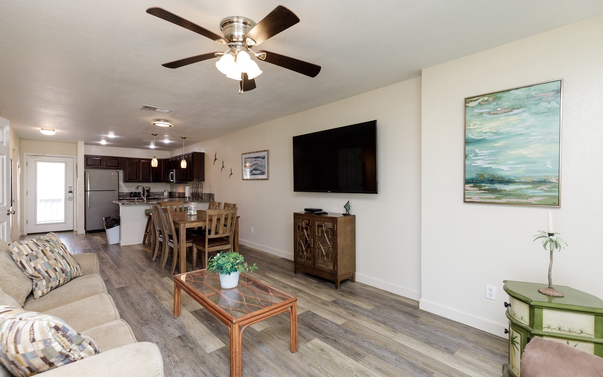 Relax in your open-concept living space where rustic wood floors meet modern comfort. Unwind on the cozy sofa while dinner simmers in your fully equipped kitchen.