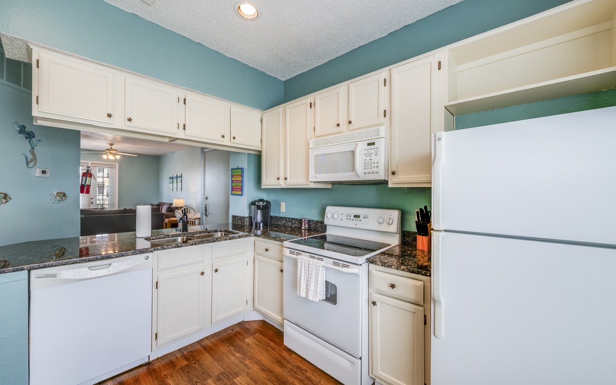 Well-appointed kitchen featuring ample cabinet space, granite countertops, and everything you need to cook breakfast, lunch, or dinner during your stay.