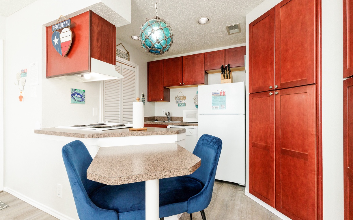 Your fully equipped kitchen features warm cherry cabinets, granite counters, and a cozy dining nook perfect for morning coffee or evening meals.