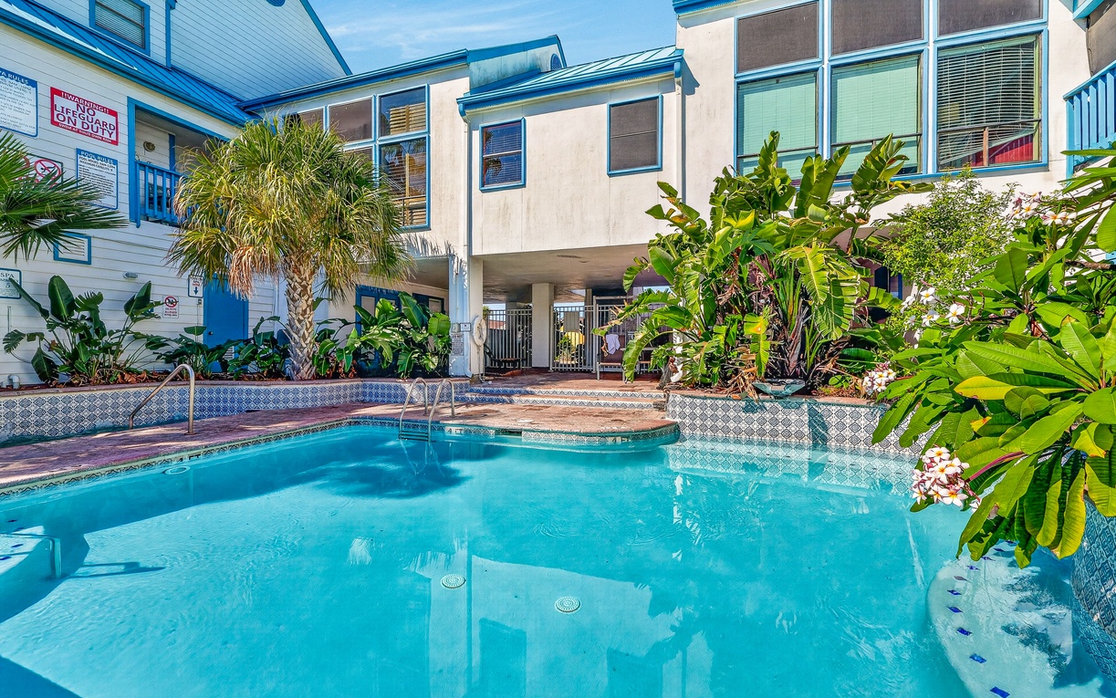 Enjoy a refreshing escape in this beautiful resort-style pool surrounded by lush tropical landscaping and charming coastal architecture. With sparkling blue water and a peaceful setting, it's the perfect place to relax and make lasting vacation memor