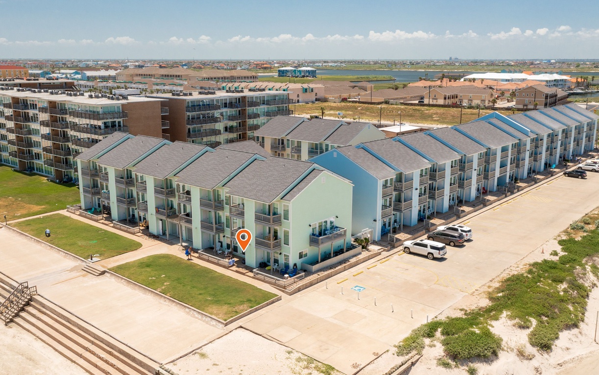 Modern beachfront resort complex with distinctive blue accents set in a developing coastal community.