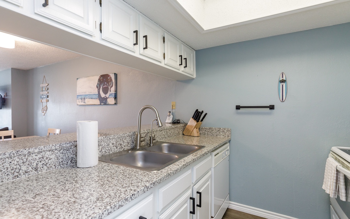 Your fully equipped kitchen features granite counters, white cabinets, and modern appliances for preparing meals during your stay.